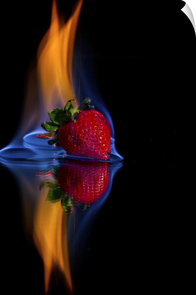 Burning strawberry on a mirror with a black background.