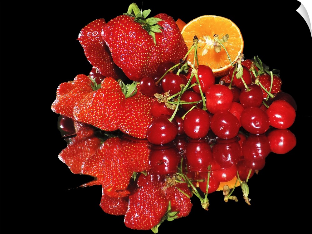 A group of red fruits including strawberries, cherries, and a slice of orange, on a mirror.
