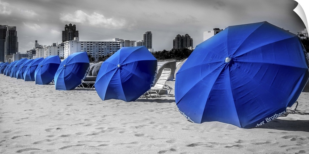 Blue beach umbrellas in the sand at the beach in Miami, Florida.