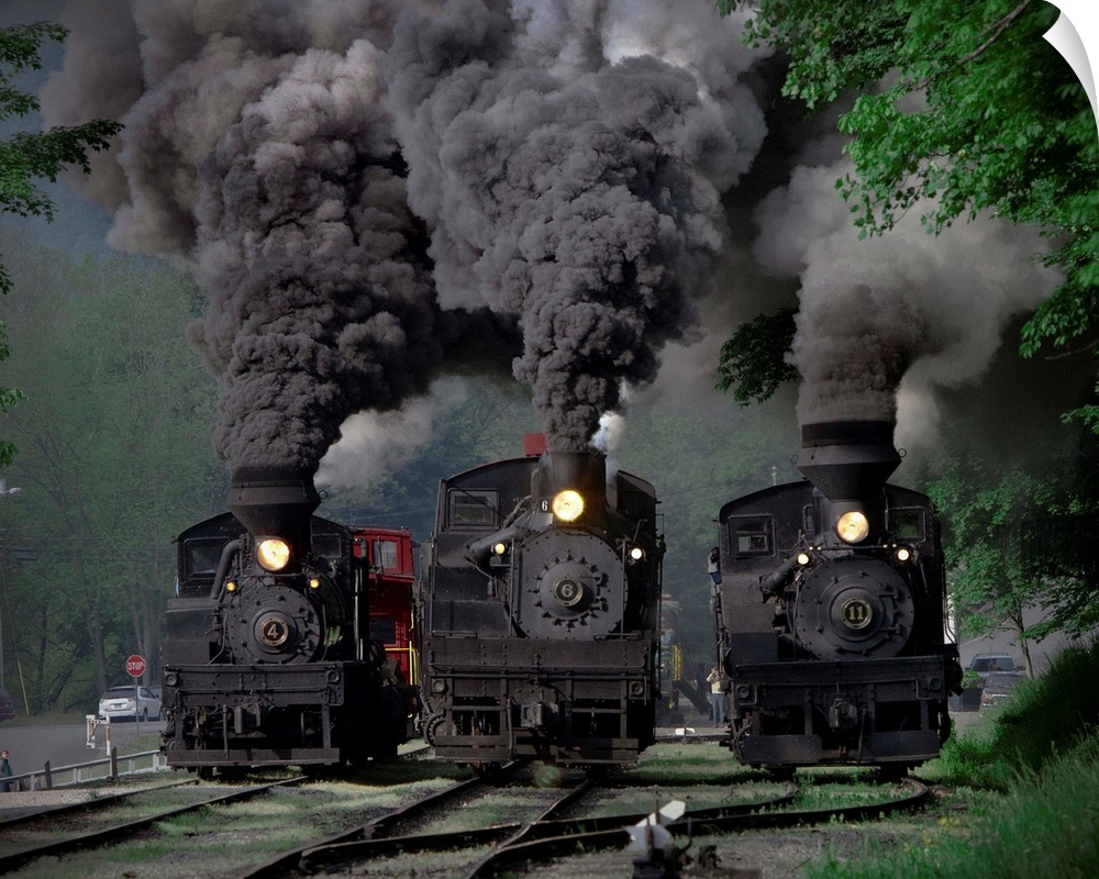 Three locomotives powering down the tracks.
