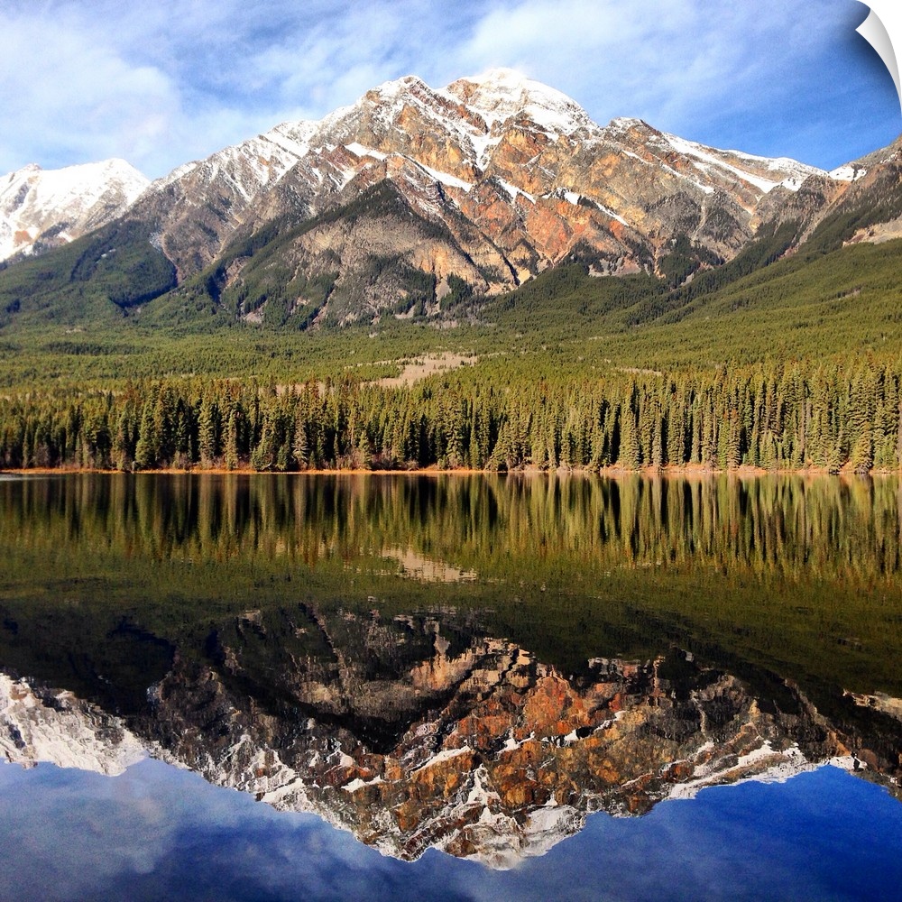 Snowy mountain peaks in Jasper, Alberta, reflected in the water below.