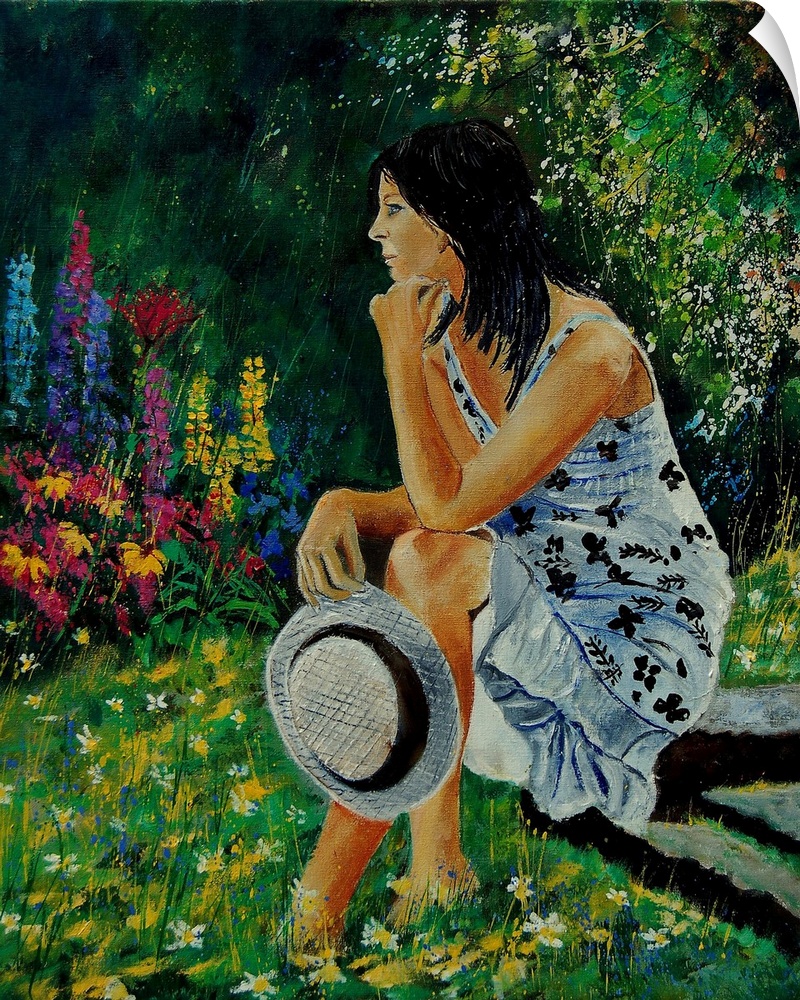 Vertical portrait of a woman sitting in a garden full of blooming flowers in the spring.