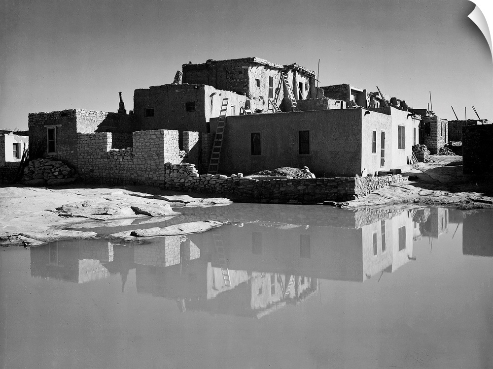 Acoma Pueblo, New Mexico, full side view of adobe house with water in foreground.