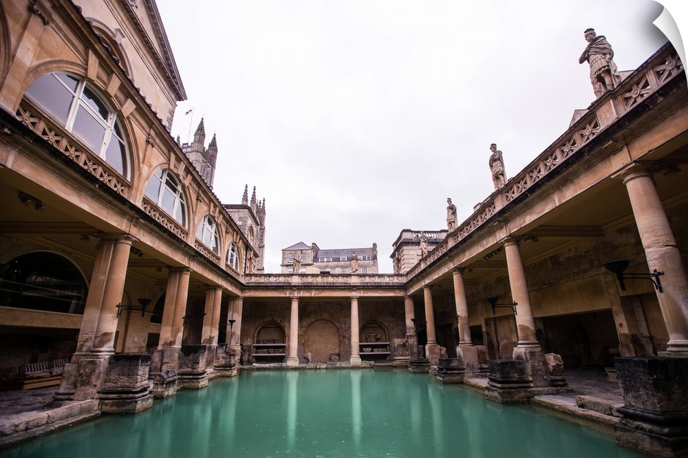 Photograph of the Great Bath in England with gray, cloudy skies above, Bath, England, UK