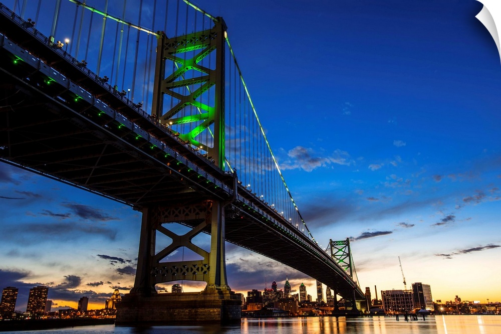 After the sun goes down, the bridge's towers and curving suspension cables emerge with a colorful phosphorescent glow.