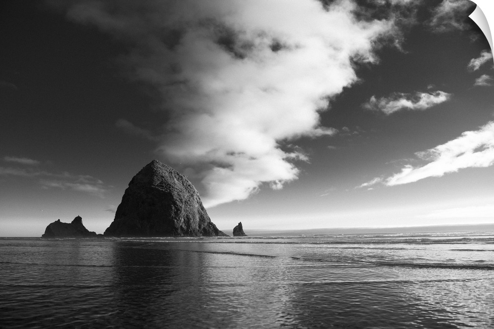 Black and white photograph of Haystack Rock with rippling waters.