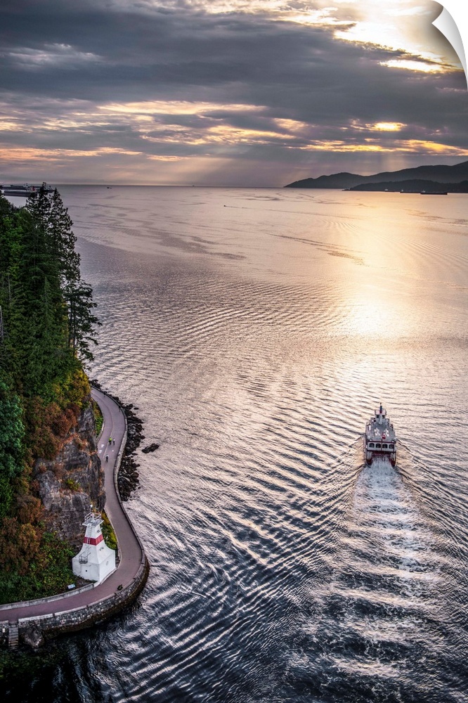 Aerial view of boat in Burrard Inlet with Stanley Park Seawall Path in Vancouver, British Columbia, Canada.