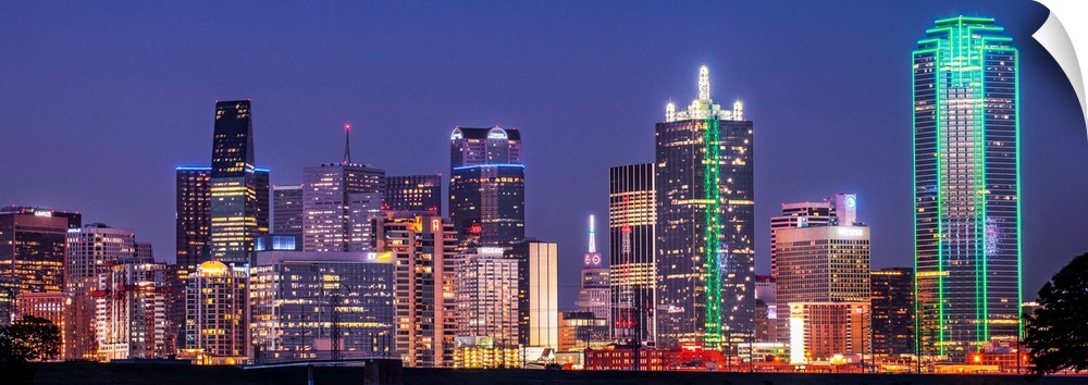 A horizontal image of the Texas city skyline at night.