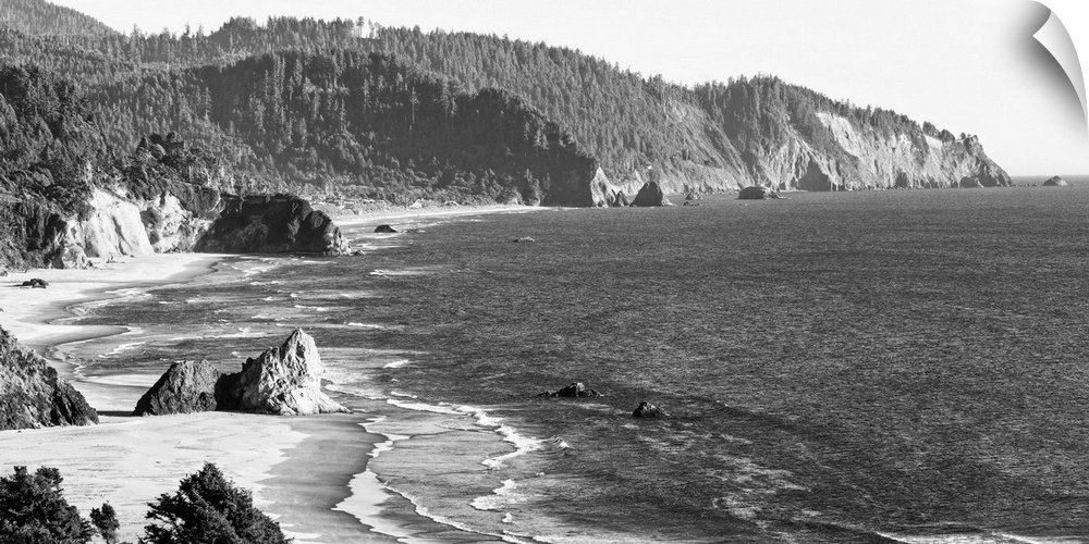 Black and white landscape photograph of the Cannon Beach shore in Oregon.