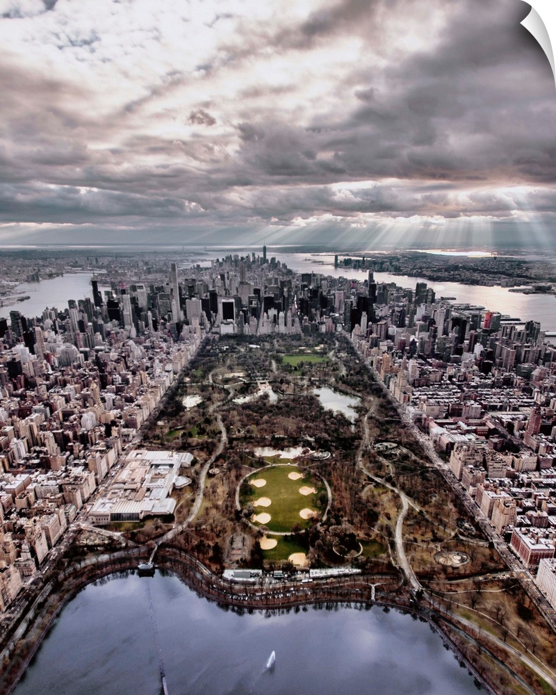 Aerial view of Central Park in New York City, surrounded by skyscrapers, under a cloudy sky.