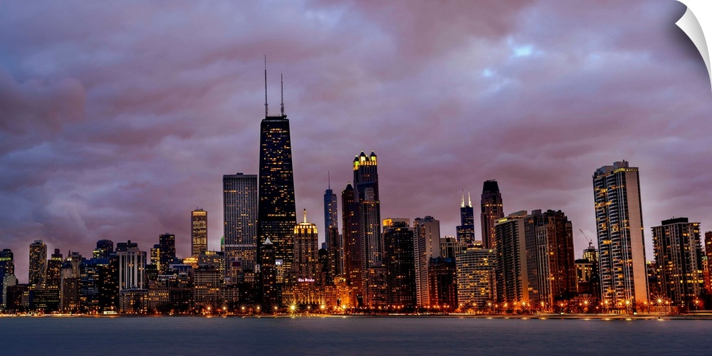 Panoramic Photo of Chicago skyline at night under dramatic clouds.