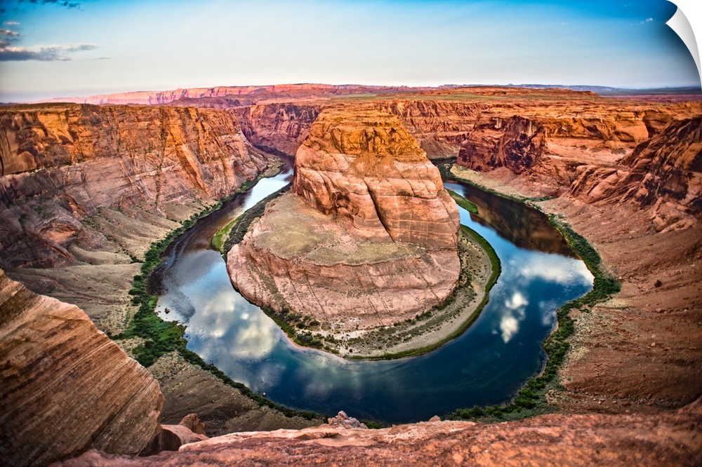 Landscape photograph of Horseshoe Bend in Page, Arizona with blue cloudy skies reflecting into the Colorado River and cont...