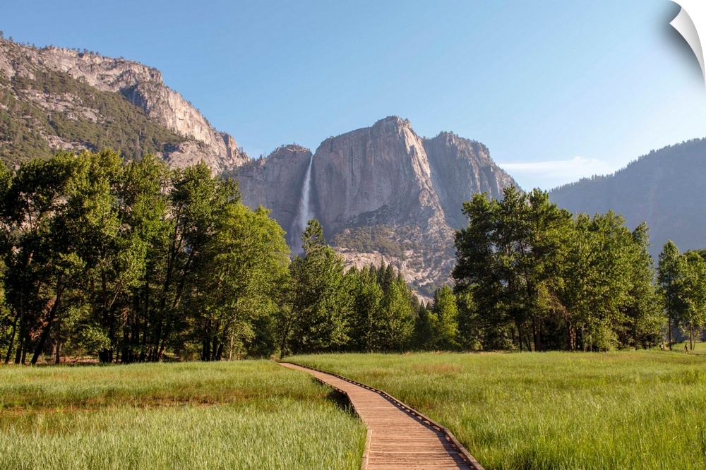 View of wooden pathway with Yosemite Falls in the background, Yosemite National Park, California.