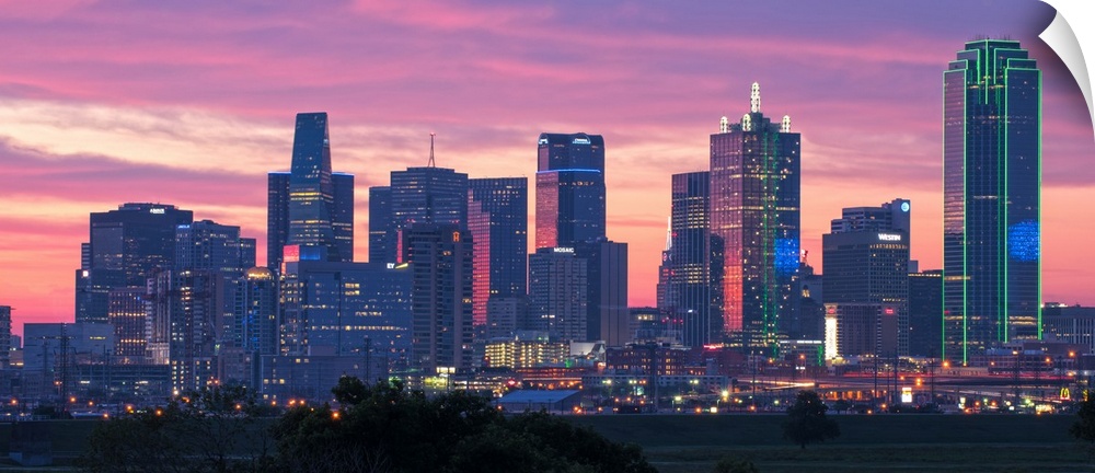 A horizontal image of the Dallas, Texas city skyline with a brilliant sunset.