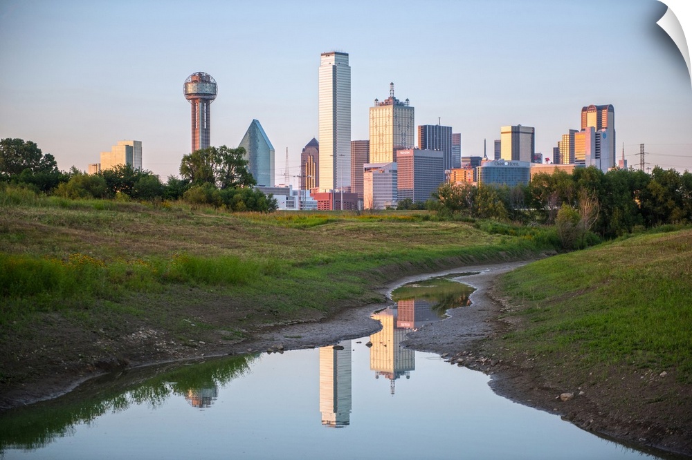 A creek in the foreground of the Dallas Texas skyline.