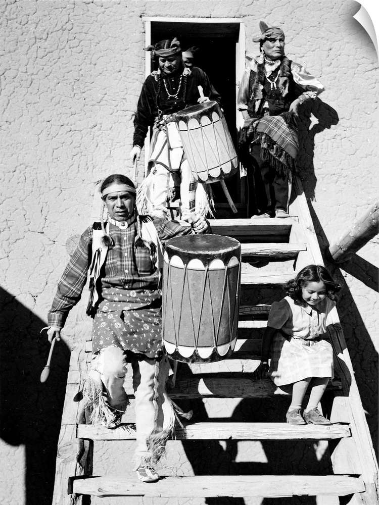 Dance, San Ildefonso Pueblo, New Mexico, 1942, two Indians descending wooden stairs, carrying drums; another Indian and ch...