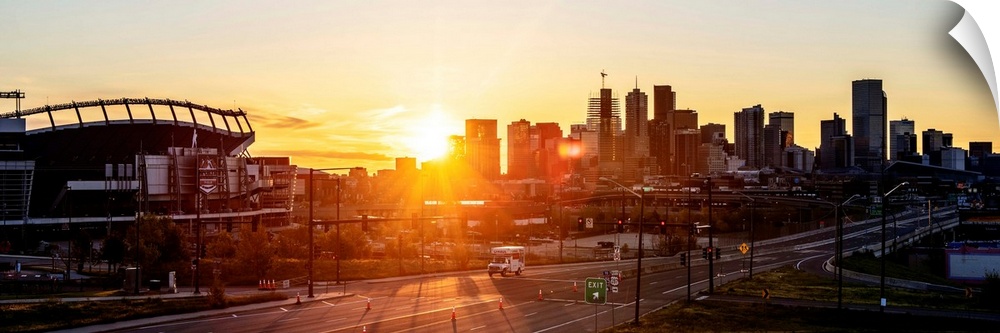 Panoramic photo of a Denver skyline against a breathtaking sunrise.