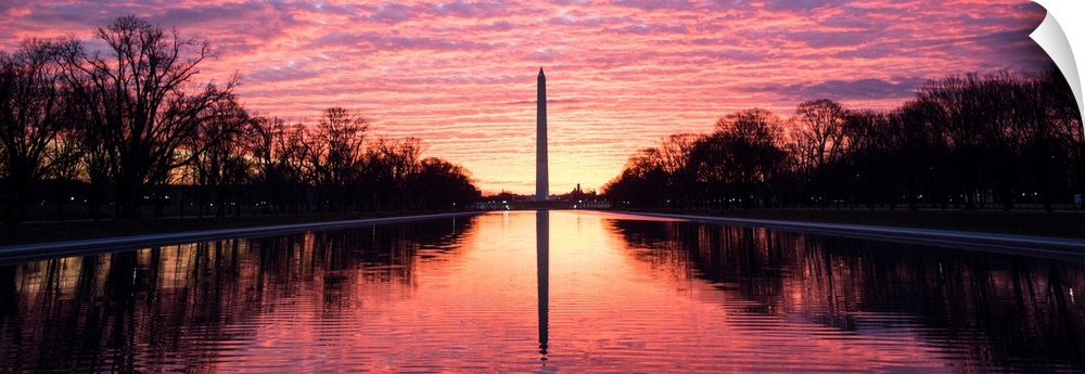 Panoramic photograph of the vibrant clouds at sunset over the Washington Monument on the National Mall in Washington, DC.