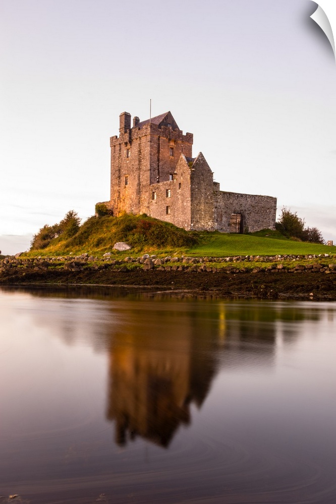Vertical photograph of the Dunguaire Castle reflecting into the water on the southeastern shore of Galway Bay in County Ga...