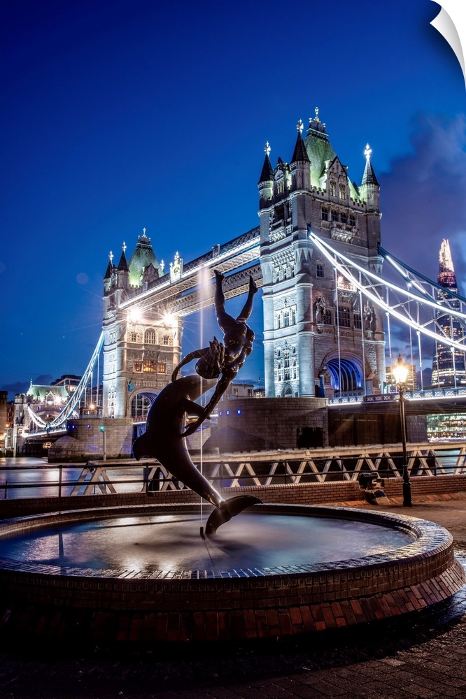 View of the Girl with a Dolphin Fountain with Bridge Tower at night in London, England.