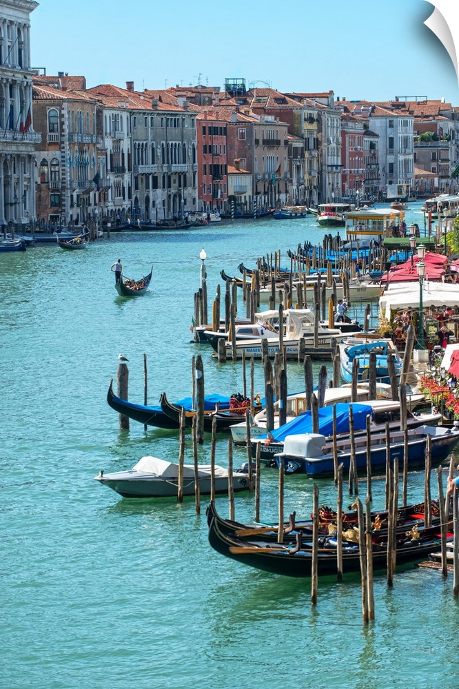 Photograph of docked gondolas and boats on the Grand Canal in Venice.