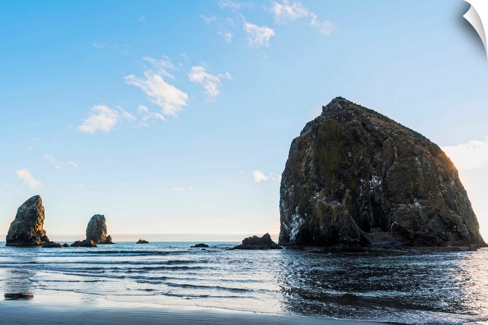 Photograph of Haystack Rock at Cannon Beach with blue skies.