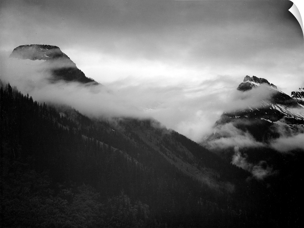 In Glacier National Park, mountain partially covered with clouds.