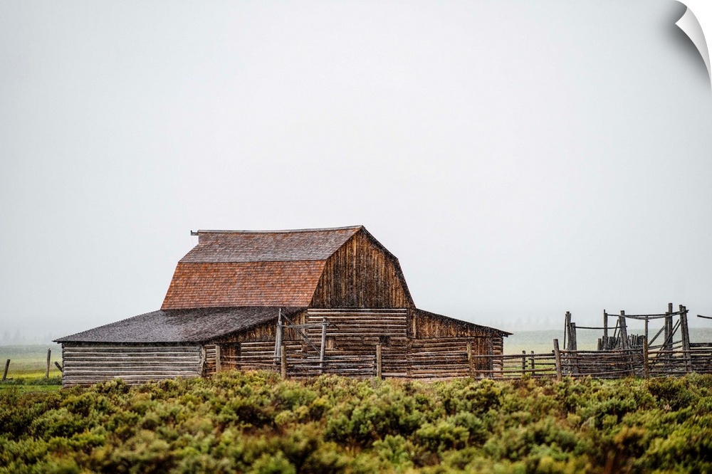 View of the John Moulton Barn with fog rolling in, Grand Teton National Park, Wyoming.