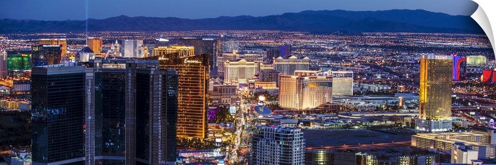 Panoramic photograph of an aerial view of the Las Vegas strip lit up at night.