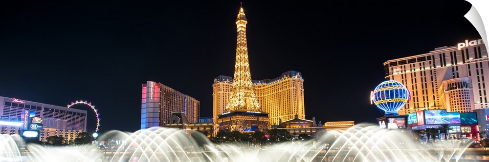 Panoramic photograph of the Las Vegas strip at night with the Bellagio Fountain water show in the foreground.