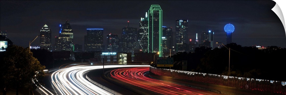 Light trails fill the foreground with Dallas skyline in the background.