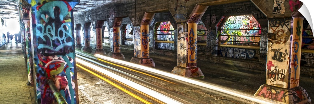 Light trails from passing cars create a bright glow, lighting up the graffiti on the walls and columsn in the Krog Street ...