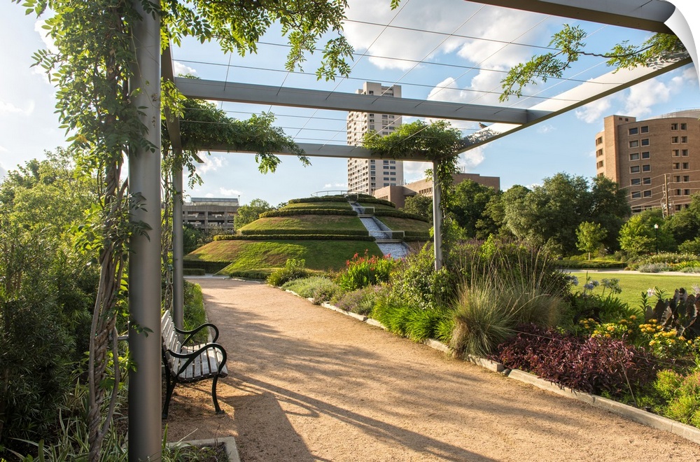 Dirt path lined with beautiful plants and flowers under a pergola in McGovern Centennial Gardens at Hermann Park in Housto...