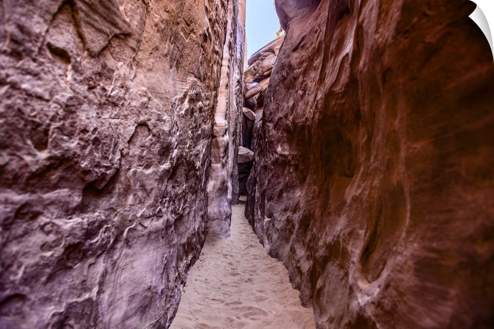 Narrow sandy trail between red sandstone fins on the way to Sand Dune Arch, Arches National Park, Moab, Utah.