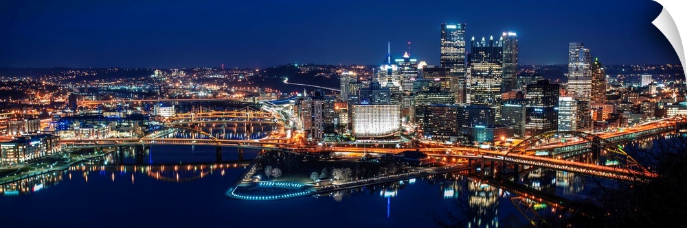 Panoramic photo of downtown Pittsburgh at night with Point State park.