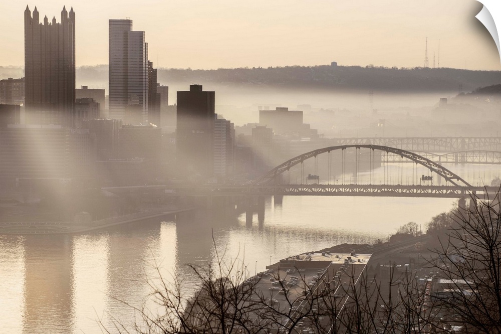 View of downtown Pittsburgh with Fort Pitt Bridge over the Monongahela River on a foggy day.