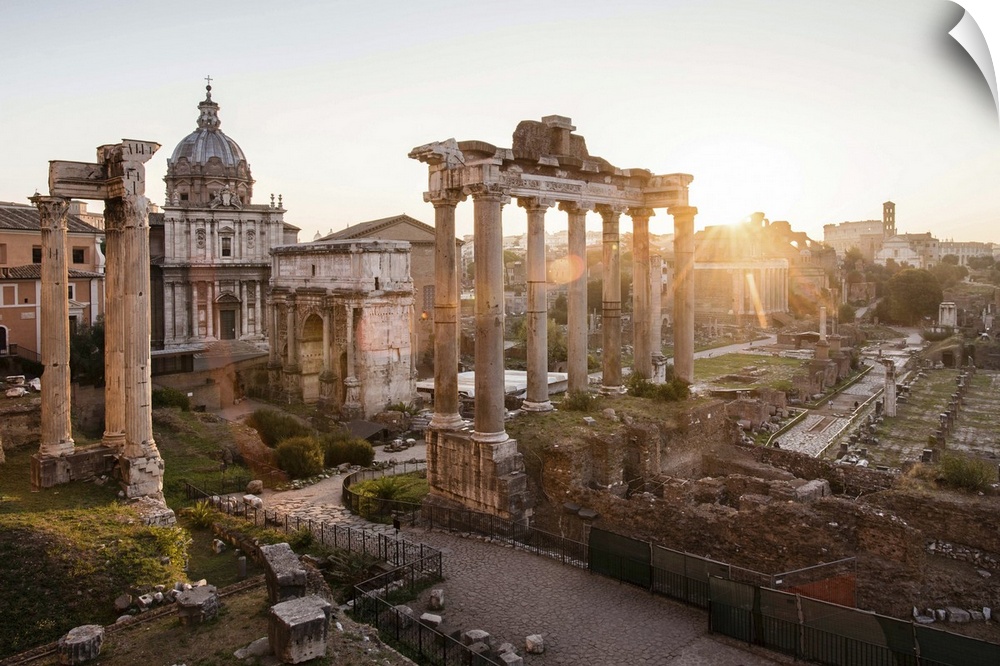 Photograph of the ruins at the Roman Forum with the sun shining in the background.