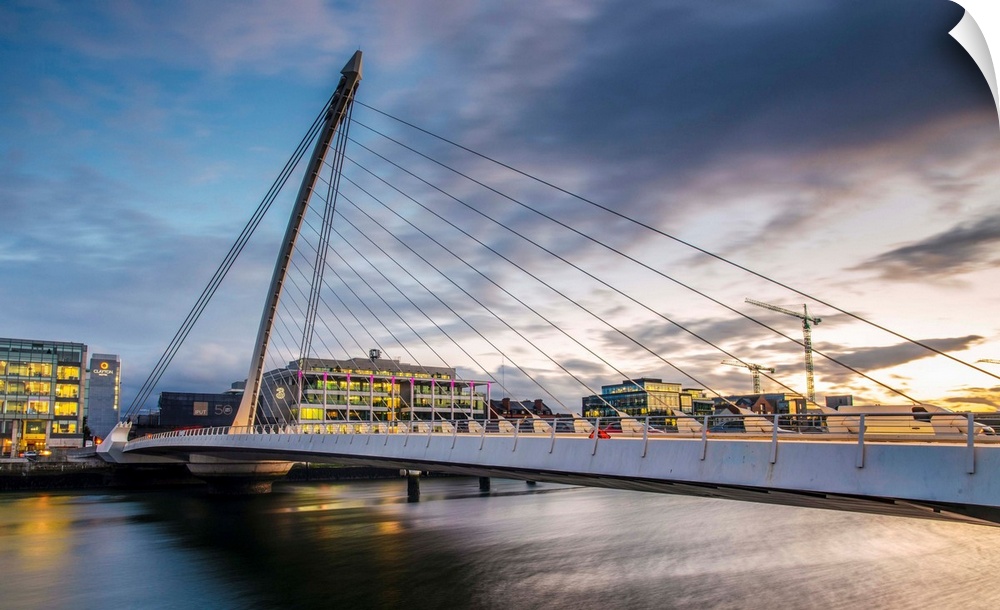 Photograph of the Samuel Beckett Bridge, a cable-stayed bridge in Dublin, Ireland going across the River Liffey, at sunset.