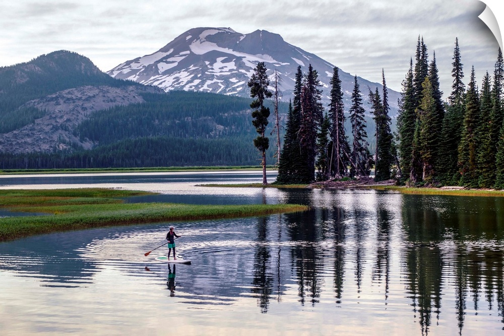 View of a paddle board surfer at Sparks Lake with South Sister peak in the background, Deschutes National Forest in Oregon.