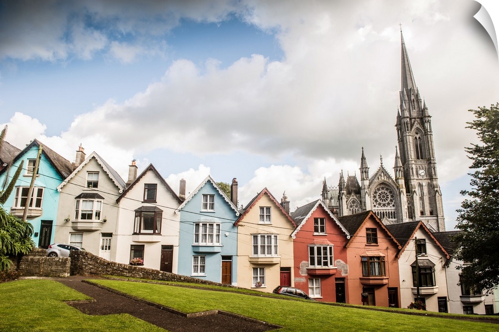 Colorful facades from a row of houses in the Old Town, with St. Colman's cathedral in the background, Cobh, County Cork, I...