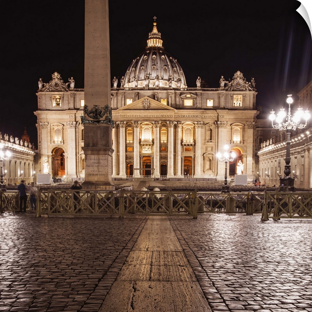 Square photograph of St. Peter's Basilica  lit up at night.