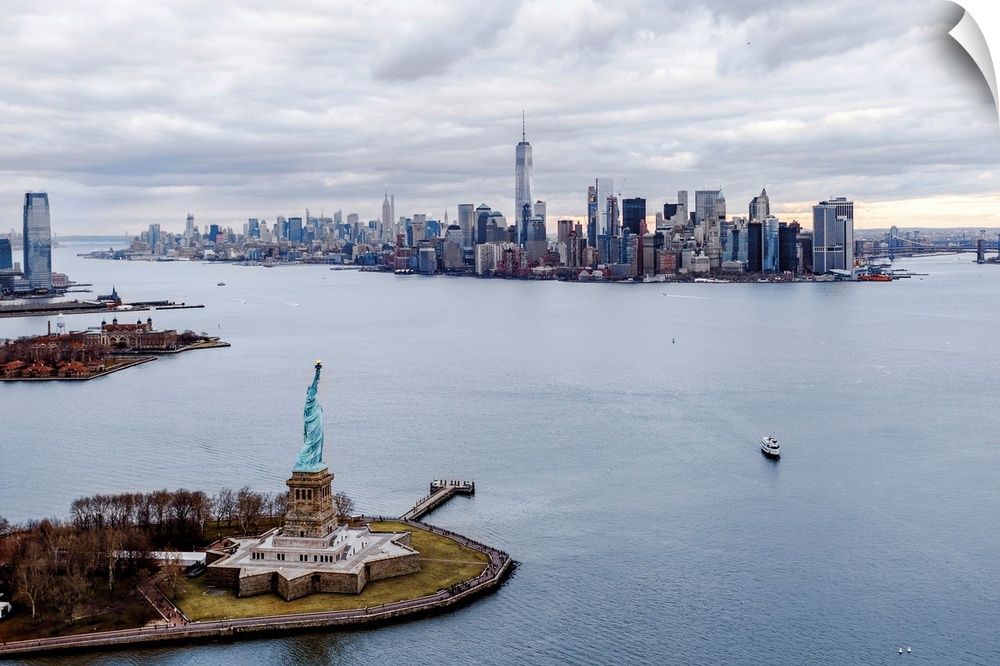 Aerial view of the Statue of Liberty on Liberty Island with the New York City skyline in the distance.
