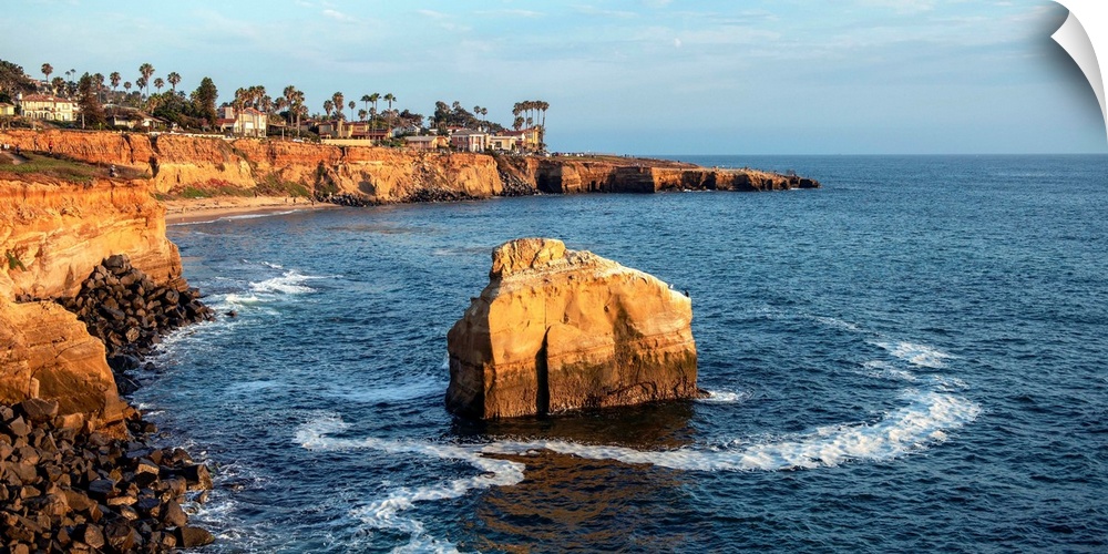 The sun sets on a lone boulder in San Diego. The Sunset Cliffs are known for their picturesque landscape.