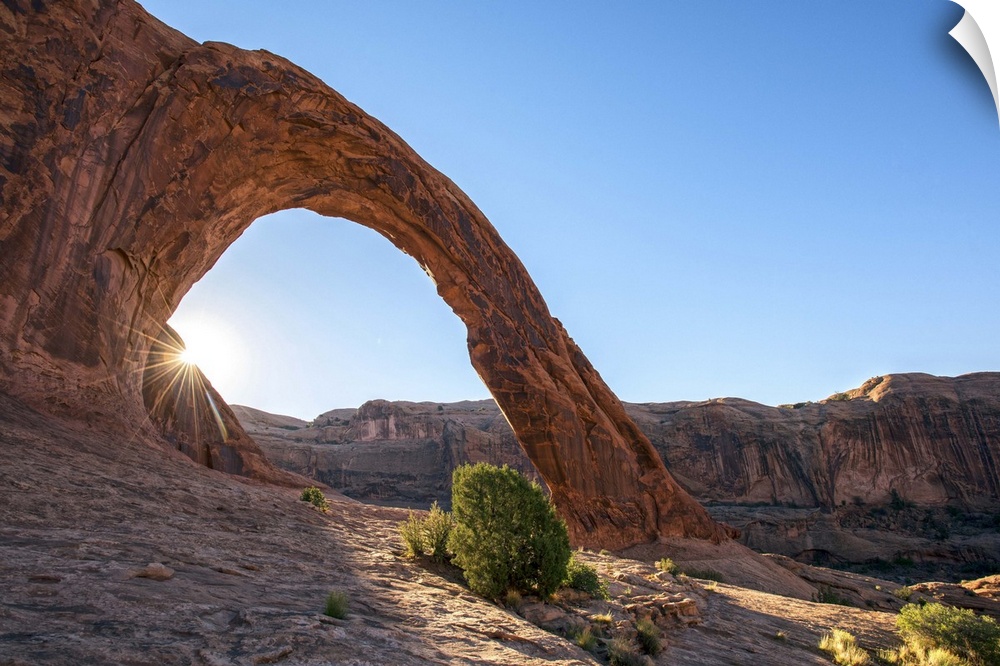 Sunlight shining on the desert landscape around the Corona Arch, Arches National Park, Utah.