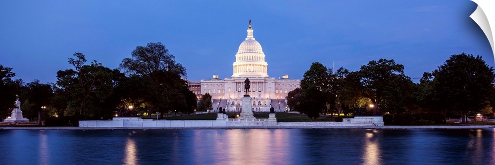 Panoramic photograph of the U.S. Capitol Building at dusk with blue and magenta hues from the Capitol Reflecting Pool.