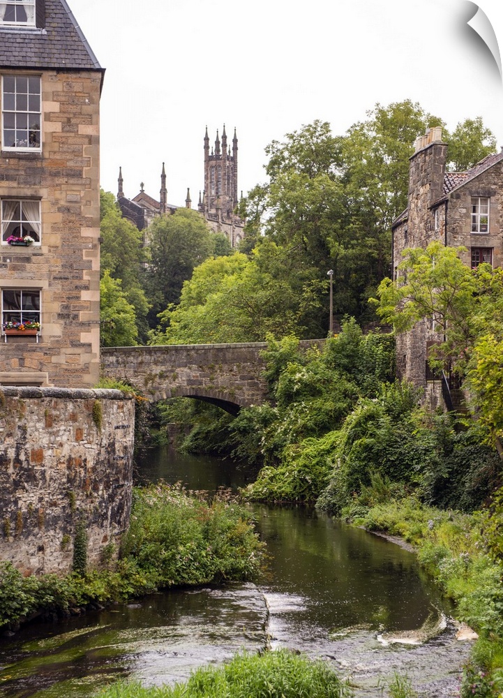 Beautiful photograph of Water of Leith river flowing through Edinburgh architecture and under a bridge in Scotland, UK.