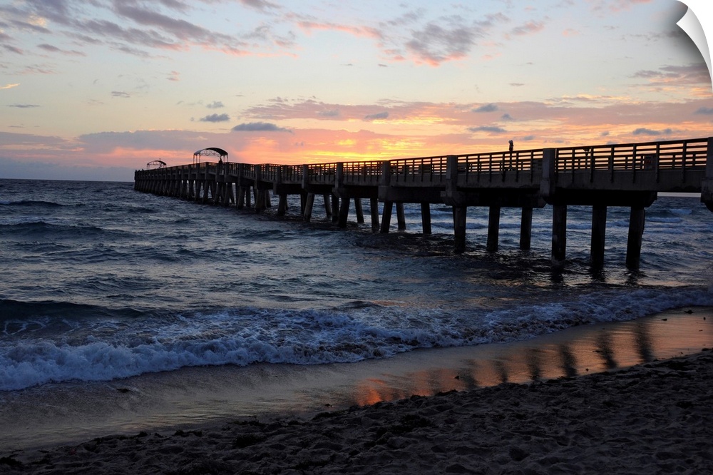 The sun rises over an Atlantic Ocean pier.