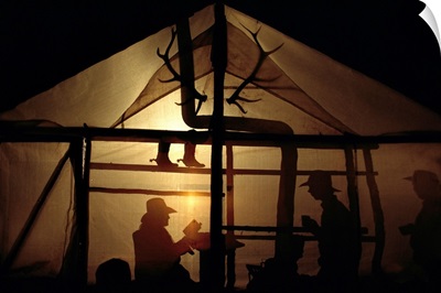 Trail guides spend the night at a camp, their shadows cast against the tent walls