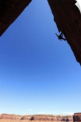 A rock climber tackles an overhanging wall on the cliffs of Indian Creek, Utah