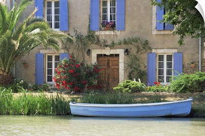 Boat moored alongside house on the bank of the Canal du Midi, France